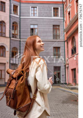 Portrait of tourist redhead woman taking photo of architecture on retro film camera Portrait of tourist redhead woman taking photo of architecture on retro film camera 79679747