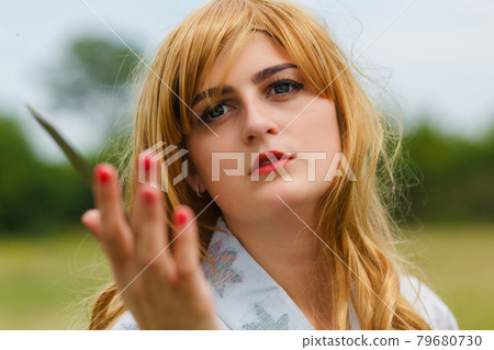 Asian woman holding a sword in a warrior position. 79680730