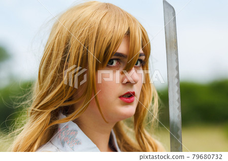 Asian woman holding a sword in a warrior position. 79680732