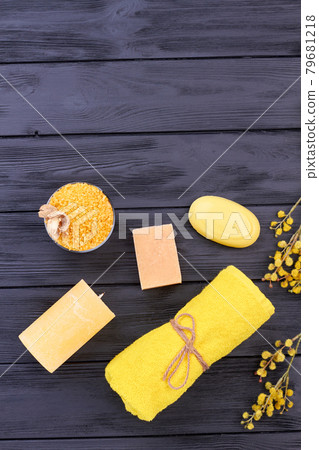 Vertical shot yellow bathroom stuff on black wood. 79681218