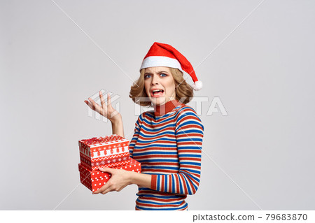 happy woman with christmas gifts in hands and red hat on head new year holidays cropped view 79683870
