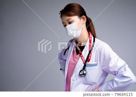 一位疲憊的年輕女醫生 79684115
