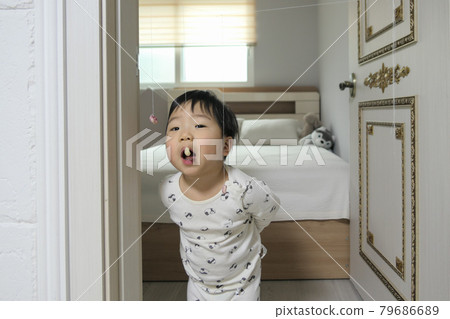 Boy playing a game of eating candy hanging from a string at home (stay-at-home play) Boy playing a game of eating candy hanging from a string at home (stay-at-home play) 79686689