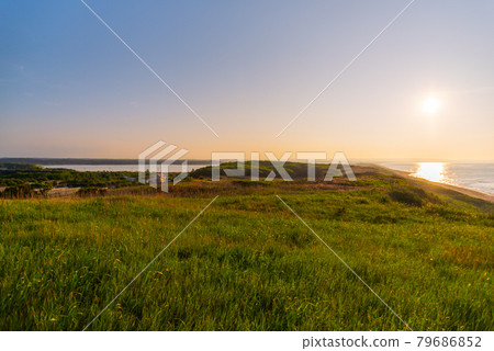 Sunset over the sea seen from the grassland on the hill [Evening scene] 79686852