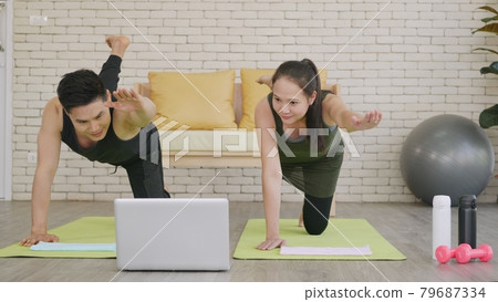 family couple doing YOGA standing meditating on virabhadrasana 3 pose workout 79687334