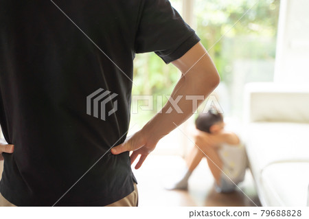 一個女孩蹲下來哭泣，一個大人看著她 79688828