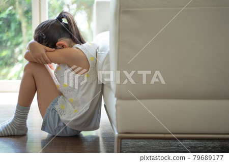 A girl burying her face in her hands and crying A girl burying her face in her hands and crying 79689177
