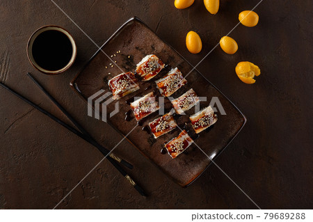 Sushi rolls with eel, cream cheese, kumquats and unagi sauce 79689288