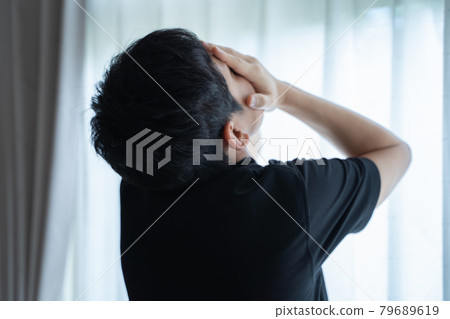 一名男子站在窗邊用手摀住臉的後視圖 79689619