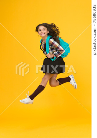 Moving with haste. Energetic child in midair yellow background. Moving with haste. Energetic child in midair yellow background. 79690938