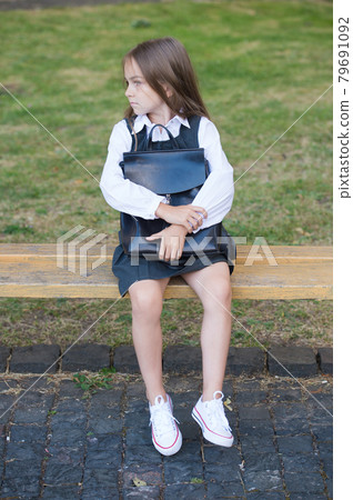 Early learning. Little child sit on bench outdoors.  79691092