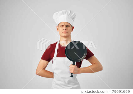 a man in a cook's uniform a frying pan in the hands of cooking a man in a cook's uniform a frying pan in the hands of cooking 79691669
