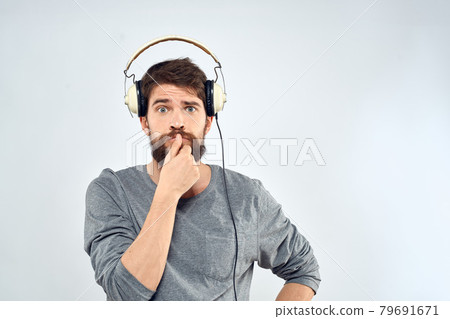 Man in headphones listens to music lifestyle modern style technology light background Man in headphones listens to music lifestyle modern style technology light background 79691671