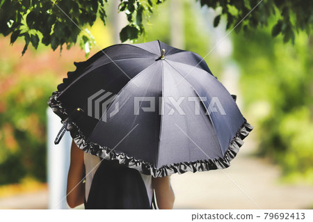 Woman with black parasol 79692413
