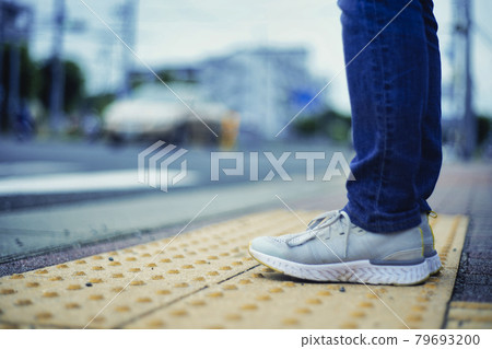 Person standing on a warning block 79693200