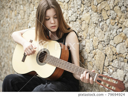 Teenage girl with a guitar Teenage girl with a guitar 79694924