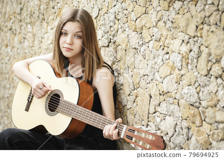 Teenage girl with a guitar Teenage girl with a guitar 79694925