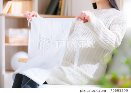 Pregnant woman preparing a T-shaped belt Pregnant woman preparing a T-shaped belt 79695299