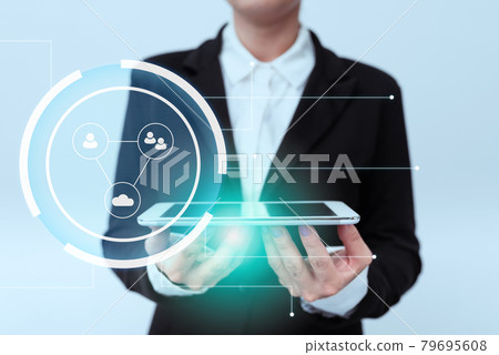 Lady In Uniform Standing Holding Phone With Two Hands Showing Modern Virtual Display. Woman In Suit Carrying Mobile Device Presenting New Futuristic Technologies. 79695608