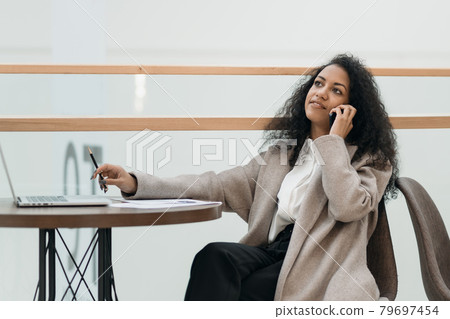 young businesswoman works sitting at a table in a food court . young businesswoman works sitting at a table in a food court . 79697454