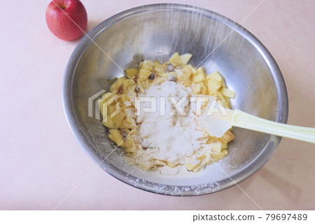 Making apple and raisin cake 79697489