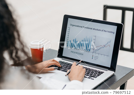 young woman checking financial data sitting at a table in a coffee shop. young woman checking financial data sitting at a table in a coffee shop. 79697512