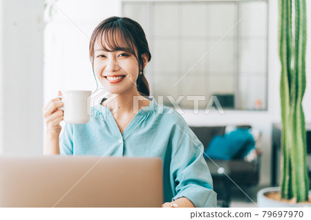 A woman using a computer in the living room A woman using a computer in the living room 79697970