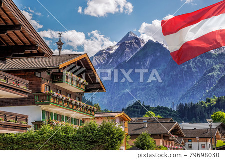 Kaprun village with hotel against Kitzsteinhorn glacier and Austrian flag in Salzburg region, Austrian Alps, Austria 79698030