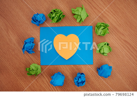 Colorful Crumpled Papers Circular Pattern Surrounding Heart Shaped Card. Blank Note Within The Flashy Pieces Of Paper Balls Arranged In A Circle. 79698124