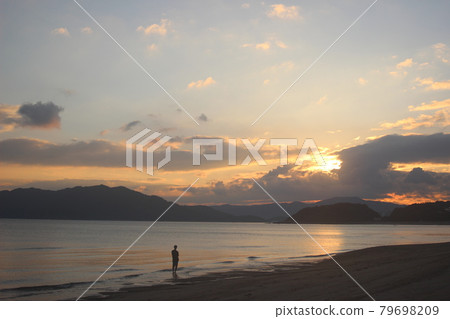 A silhouette of a man gazing at the setting sun and the rainbow-colored Seto Inland Sea! Nijigahama Beach, Hikari City, Yamaguchi Prefecture A silhouette of a man gazing at the setting sun and the rainbow-colored Seto Inland Sea! Nijigahama Beach, Hikari City, Yamaguchi Prefecture 79698209