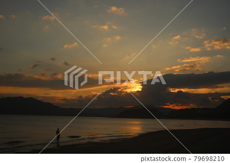 A silhouette of a man gazing at the setting sun and the rainbow-colored Seto Inland Sea! Nijigahama Beach, Hikari City, Yamaguchi Prefecture A silhouette of a man gazing at the setting sun and the rainbow-colored Seto Inland Sea! Nijigahama Beach, Hikari City, Yamaguchi Prefecture 79698210