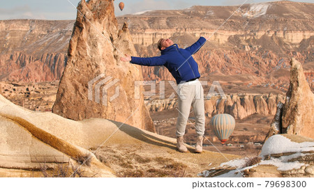 A young guy is enjoying the mountains in Cappadocia. Turkey. A young guy is enjoying the mountains in Cappadocia. Turkey. 79698300