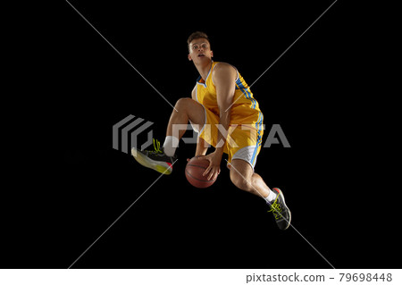 High jump. Basketball player with a ball in action and motion isolated on dark black studio background. Advertising concept. Strong Caucasian athlete practicing with basketball ball. 79698448