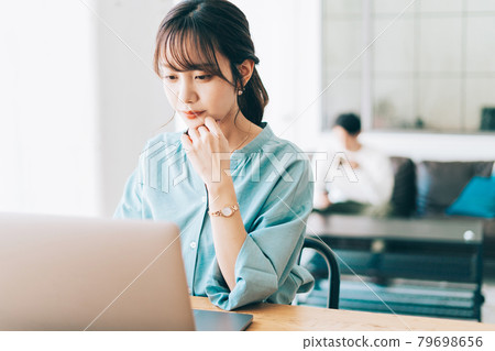 一個在家工作的女人和一個在沙發上放鬆的男人 一個在家工作的女人和一個在沙發上放鬆的男人 79698656