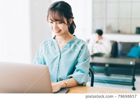 一個在家工作的女人和一個在沙發上放鬆的男人 一個在家工作的女人和一個在沙發上放鬆的男人 79698657
