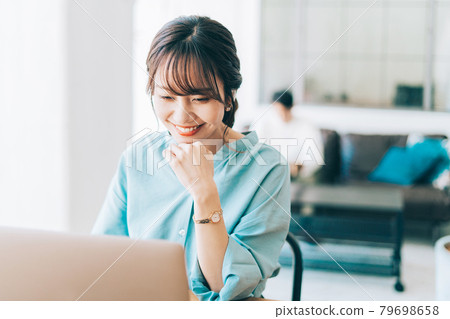 一個在家工作的女人和一個在沙發上放鬆的男人 一個在家工作的女人和一個在沙發上放鬆的男人 79698658