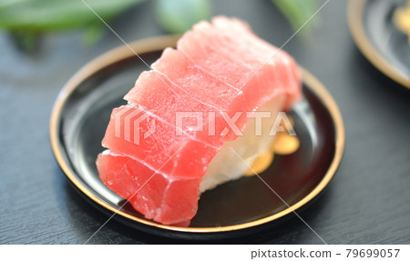 A piece of medium fatty tuna served on a black lacquerware plate A piece of medium fatty tuna served on a black lacquerware plate 79699057