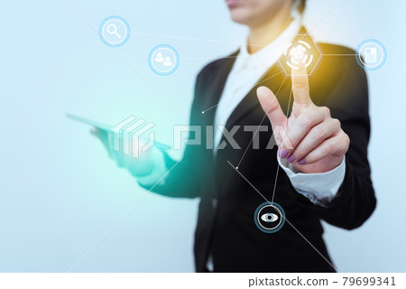 Woman In Suit Side Standing Holding Tablet While Raising Finger Showing Futuristic Interface. Lady In Uniform Carrying Mobile Phone Pointing On Modern Graphic Display. 79699341