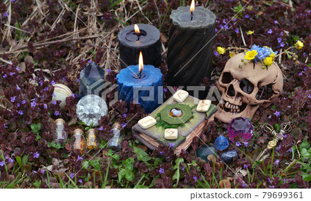 Beltane ritual with skull, book of spells, bottles with potion, spring flowers outside. Esoteric, gothic and occult background, Halloween mystic and wicca concept. Beltane ritual with skull, book of spells, bottles with potion, spring flowers outside. Esoteric, gothic and occult background, Halloween mystic and wicca concept. 79699361