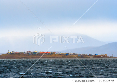 View from the sea to the Chukchi village of Yanrakynnot, located on the shores of the Senyavin Strait of the Bering Sea, surrounded by tundra and mountains. View from the sea to the Chukchi village of Yanrakynnot, located on the shores of the Senyavin Strait of the Bering Sea, surrounded by tundra and mountains. 79700676