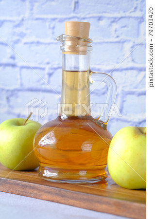 apple vinegar in glass bottle with fresh green apple on table apple vinegar in glass bottle with fresh green apple on table 79701420