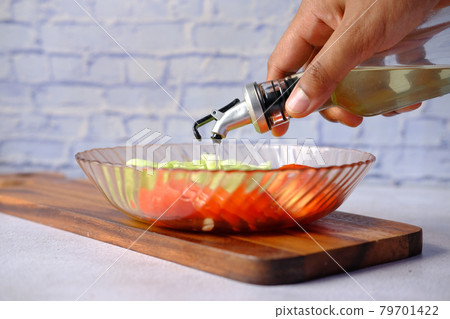 Pouring vegetable oil into a bowl close up Pouring vegetable oil into a bowl close up 79701422