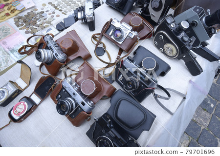 Vintage made in USSR photo cameras placed on a tray for sale. Flea market. 79701696