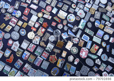 Pile of an old Soviet USSR pins medals badges placed on a tray for sale. Flea market 79701698