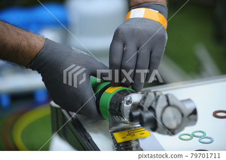 Plumber hands in gloves cut plastic pipes with the polyfusion welding machine 79701711