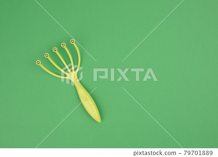 manual green plastic head massager with metal balls on green background manual green plastic head massager with metal balls on green background 79701889