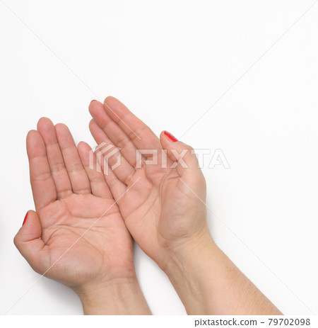 two female hands with red painted nails in a prayer pose on a white background 79702098