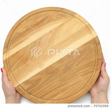 woman hand holding empty round wooden pizza board in hand, body part on white background 79702099
