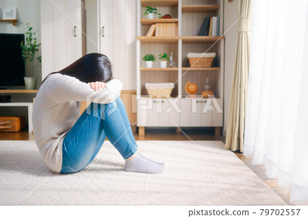 Woman hiding her face 79702557