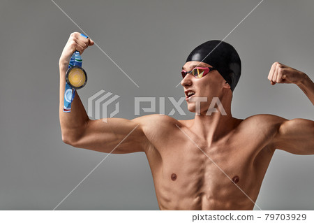 Joyful athlete swimmer with a medal in his hands positive emotions, joy of victory, the concept of success, never give up and you will achieve success 79703929